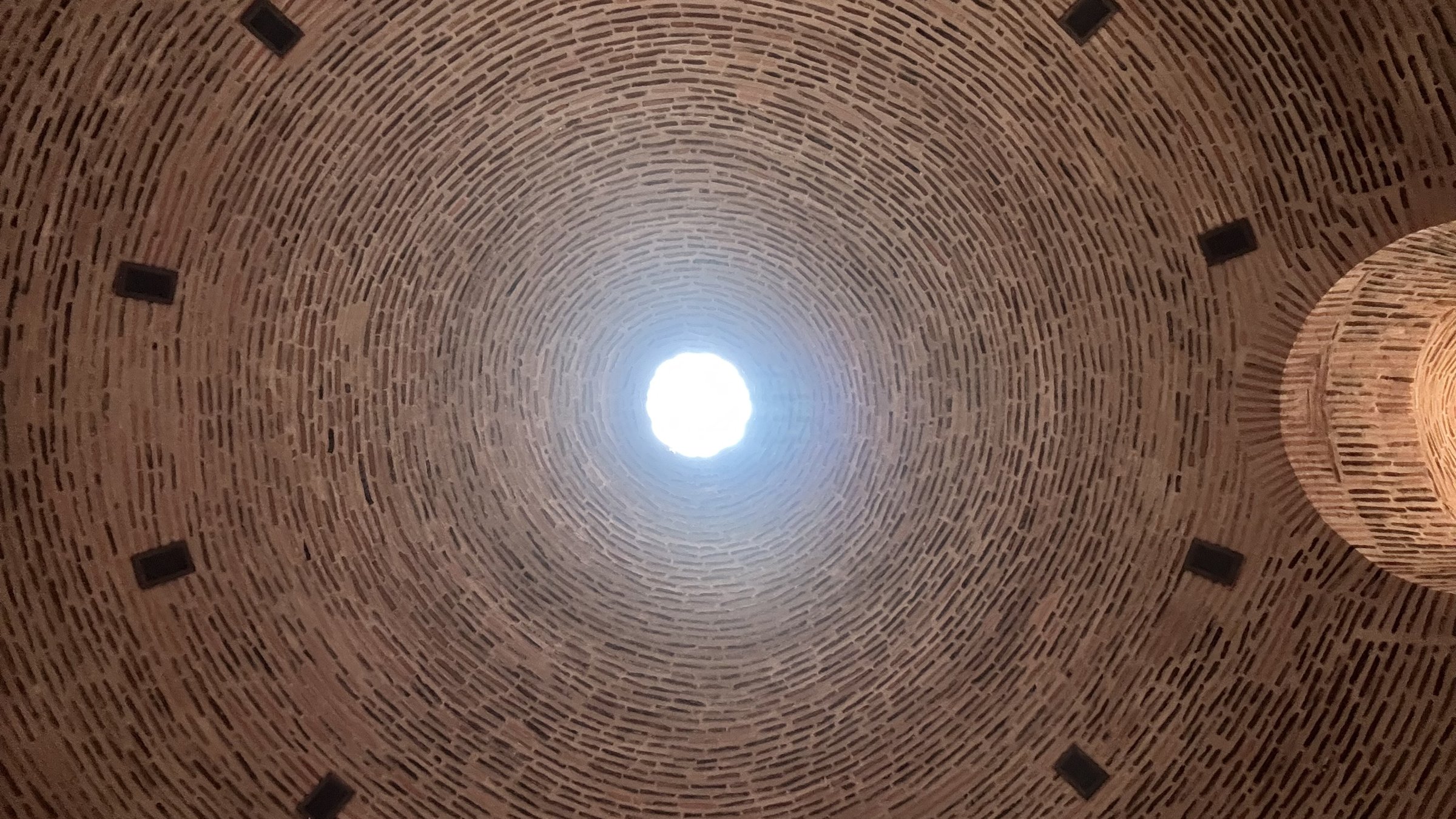 Blick in eine Ziegelkuppel mit Lichtöffnung – Symbol für das innere Licht